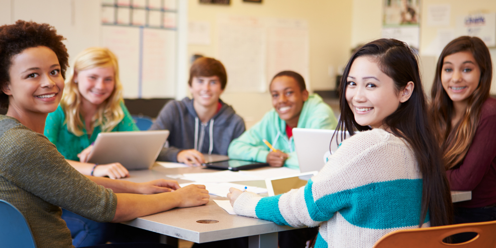 students at a table smiling