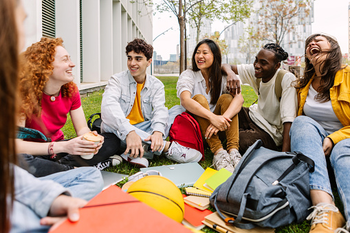 Student friendship concept with diverse classmate friends sitting on campus park