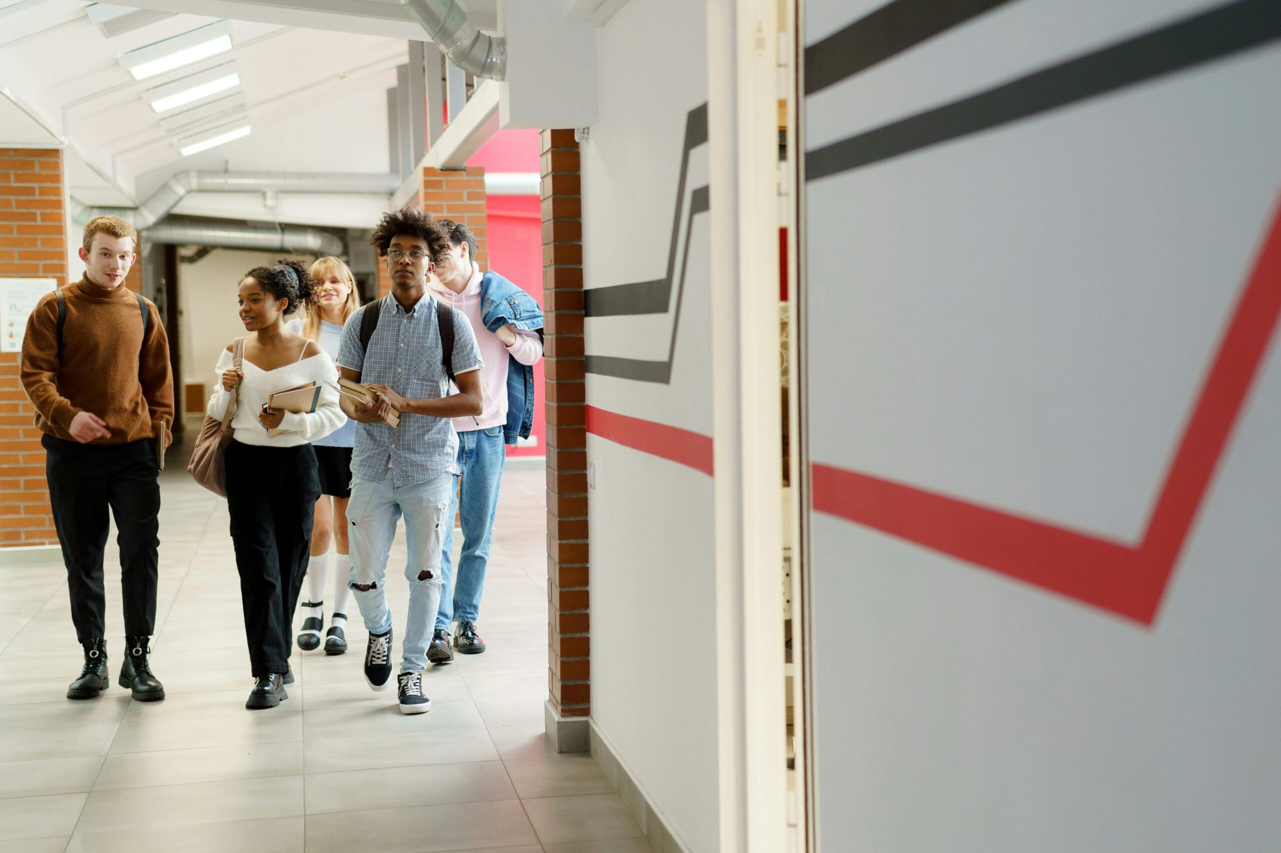 pexels-photo-6209356-6209356 A diverse group of teenagers walking together in a modern school hallway.